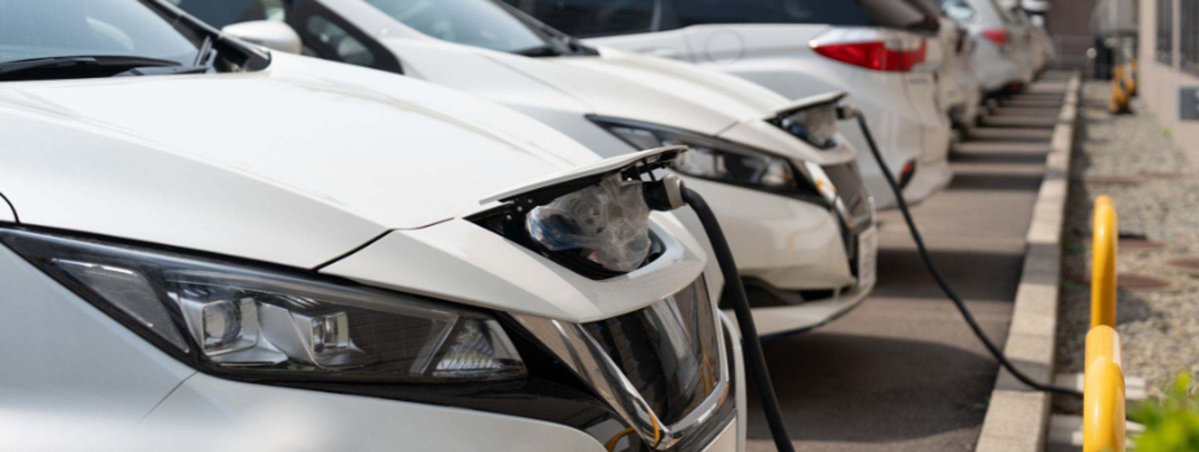 Řada zaparkovaných a nabíjejících se elektromobilů